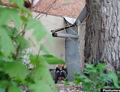 Sexy blondie empties her bladder behind a building