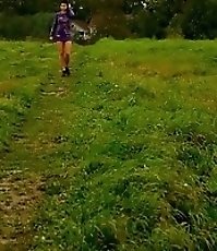 Girl pulls the hem of her dress up to pee outdoors